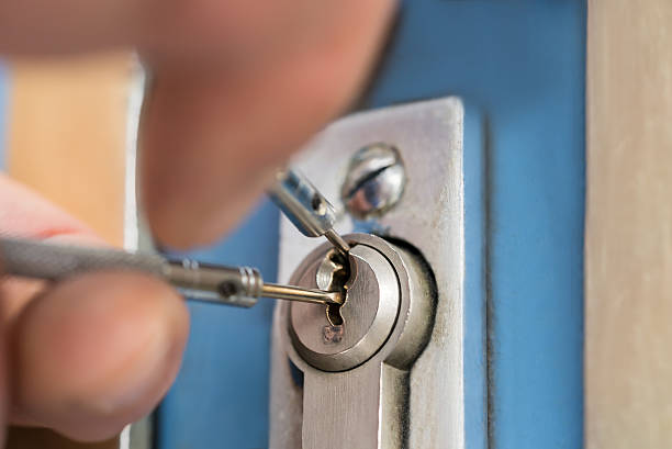 Close-up Of Lockpicker Hand Fixing Door Handle At Home Close-up Of Lockpicker Hand Fixing Door Handle At Home